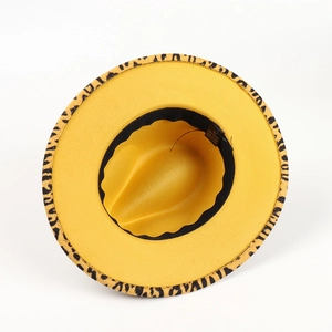 Detail view of yellow felt fedora hat interior showing 100% polyester label and leopard brim