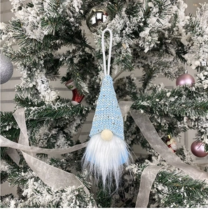Blue knitted faceless gnome ornament hanging on a snowy Christmas tree branch
