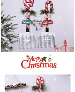 Detail of wooden shovel-shaped Christmas wall hanging with festive Noel and Welcome signs
