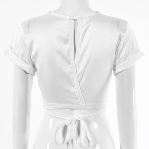 Detail view of white satin crop top featuring a back slit and elegant waist tie-up knot