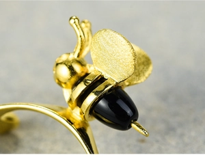 Macro shot of 925 silver bee ring with detailed black finish and golden metal texture