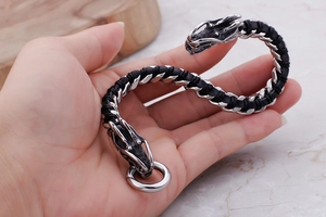 Detail of silver dragon head clasp on black braided leather bracelet for men