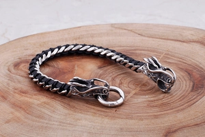 Macro detail of high-precision steel dragon head clasp on black braided leather bracelet