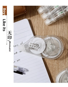 Close-up of 30M large capacity correction tape with transparent shell on wooden desk