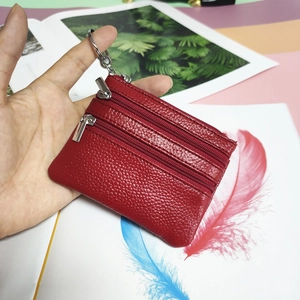 Detail of red genuine leather coin purse with three zipper pockets and keyring attachment