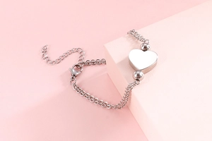 Détail du bracelet double couche avec cœur en argent et fermoir mousqueton sur rose
