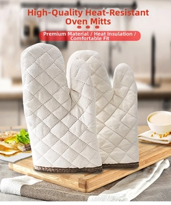 Vertical view of white quilted cotton oven mitts with brown trim on a wooden board