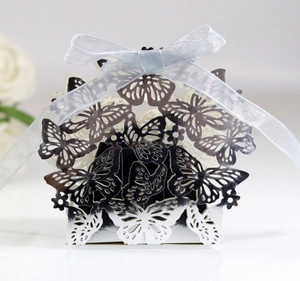 Macro detail of laser-cut butterfly candy box with elegant silver finish and blue ribbon