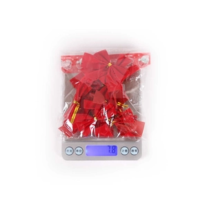 Detailed view of red mini Christmas bows on a scale showing 7.8g lightweight material