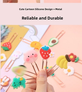 Close-up of cute cartoon silicone charms with rose gold metal paperclip bookmarks