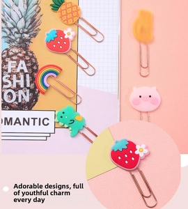 Detail of rose gold cartoon bookmarks with strawberry and rainbow silicone charms