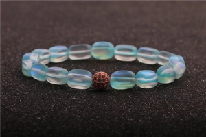 Macro shot of moonstone bead bracelet with a zircon-encrusted copper sphere charm