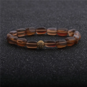 Detailed macro view of moonstone bracelet with brown matte beads and a golden zircon ball