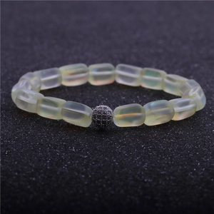 Macro shot of pale yellow beaded bracelet with a micro-paved dark zircon silver ball