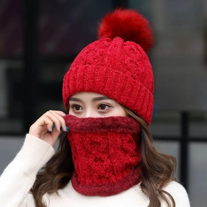 Dettaglio del cappello in maglia rossa con pompon e scaldacollo coordinato sul modello
