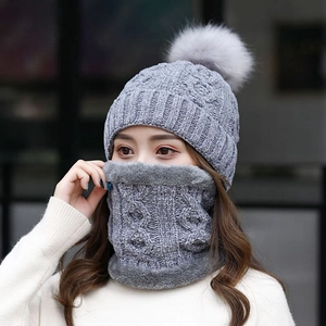 Dettaglio del set invernale in maglia grigia con cappello a pompon e scaldacollo coordinato