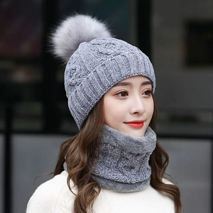 Dettaglio del set invernale in maglia grigia con cappello a pompon e scaldacollo