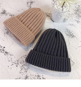 Close-up of thick ribbed knit beanies with warm white fleece lining in khaki and grey