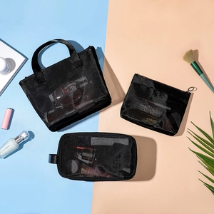 Three-piece black mesh makeup bag set including tote and zip pouches on blue background