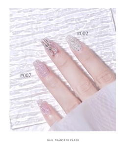Macro shot of glitter nail transfer paper with metallic bow decoration in codes #002 and #007