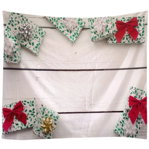 Detailed view of Christmas tapestry featuring red gift boxes on white wooden texture background