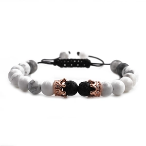 Detail of white howlite beads and lava stones with rose gold crown on braided bracelet