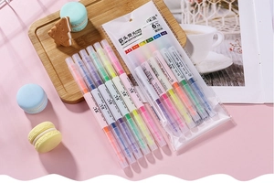 Detailed view of six dual-tip highlighters in assorted colors on a pastel pink background