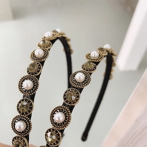 Detail of baroque headband with olive green crystals and pearls on slim gold frame
