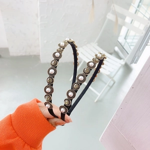Close-up of Baroque style headband with pearls and crystals on vintage gold base