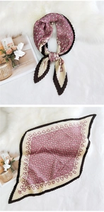 Macro detail of pleated silk scarf with pink chain pattern and brown border