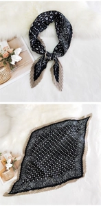 Detail of pleated silk scarf with black and beige geometric paisley patterns