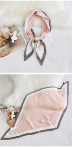 Detail of pleated silk scarf featuring pink houndstooth pattern and contrast border