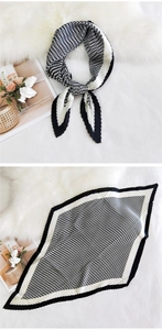 Close-up of pleated silk scarf with classic black and white houndstooth pattern detail