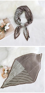 Detail of pleated silk scarf with geometric pattern and earthy tones on plush background