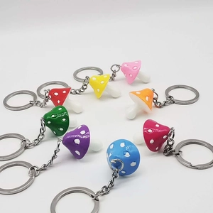 Top view of colorful resin mushroom keychains arranged in a circle on white background
