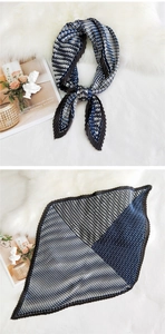 Detail of pleated silk scarf featuring geometric color blocks in navy blue and black