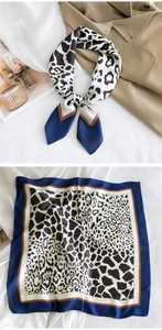 Detail of a blue animal print satin square scarf with cow and leopard patterns
