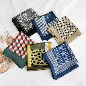 Elegant assorted silk square scarves with paisley and geometric patterns on white fabric