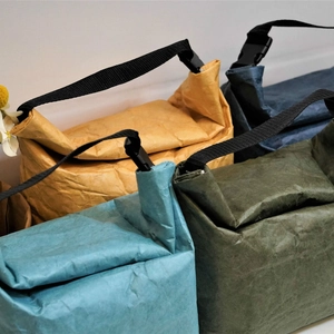 Waterproof Tyvek lunch bags in four colors with black handles and buckle closures