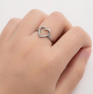 Close-up of minimalist stainless steel open heart ring worn on a finger