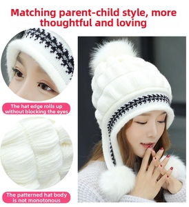 Close-up of white knitted trapper hat with soft pom-poms and geometric pattern trim