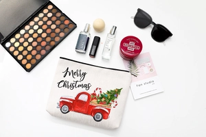 Flat lay of Christmas canvas makeup bag with festive truck print and travel accessories