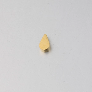 Macro shot of mirror-polished gold teardrop pendant with a 2mm hole for DIY jewelry