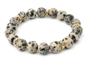 Detail of dalmatian jasper beaded bracelet with gold crystal-studded spacers on white base