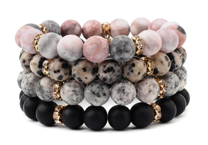 Detail of four-piece natural stone bead bracelets with gold zircon spacers and textures