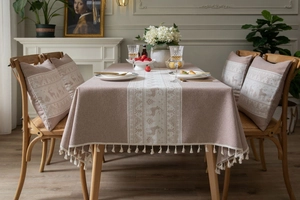 Detail of green Christmas tablecloth with deer pattern, linen fabric and tassel edges