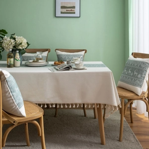 Green and beige tablecloth with tassel fringe and matching reindeer throw pillow set