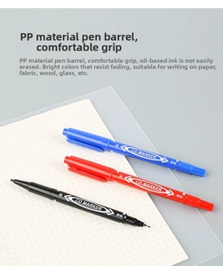 Detail of oil-based dual-tip markers in black, red, and blue on a grid background