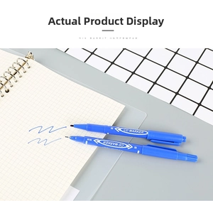 Close-up of blue dual-tip permanent markers on a grid notebook with handwritten strokes