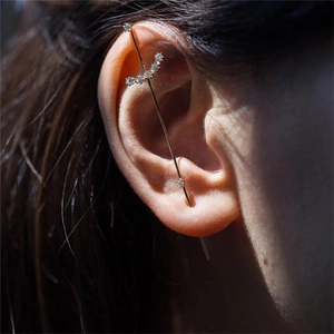 Detail of gold piercing earring bar featuring five sparkling heart-shaped zircons